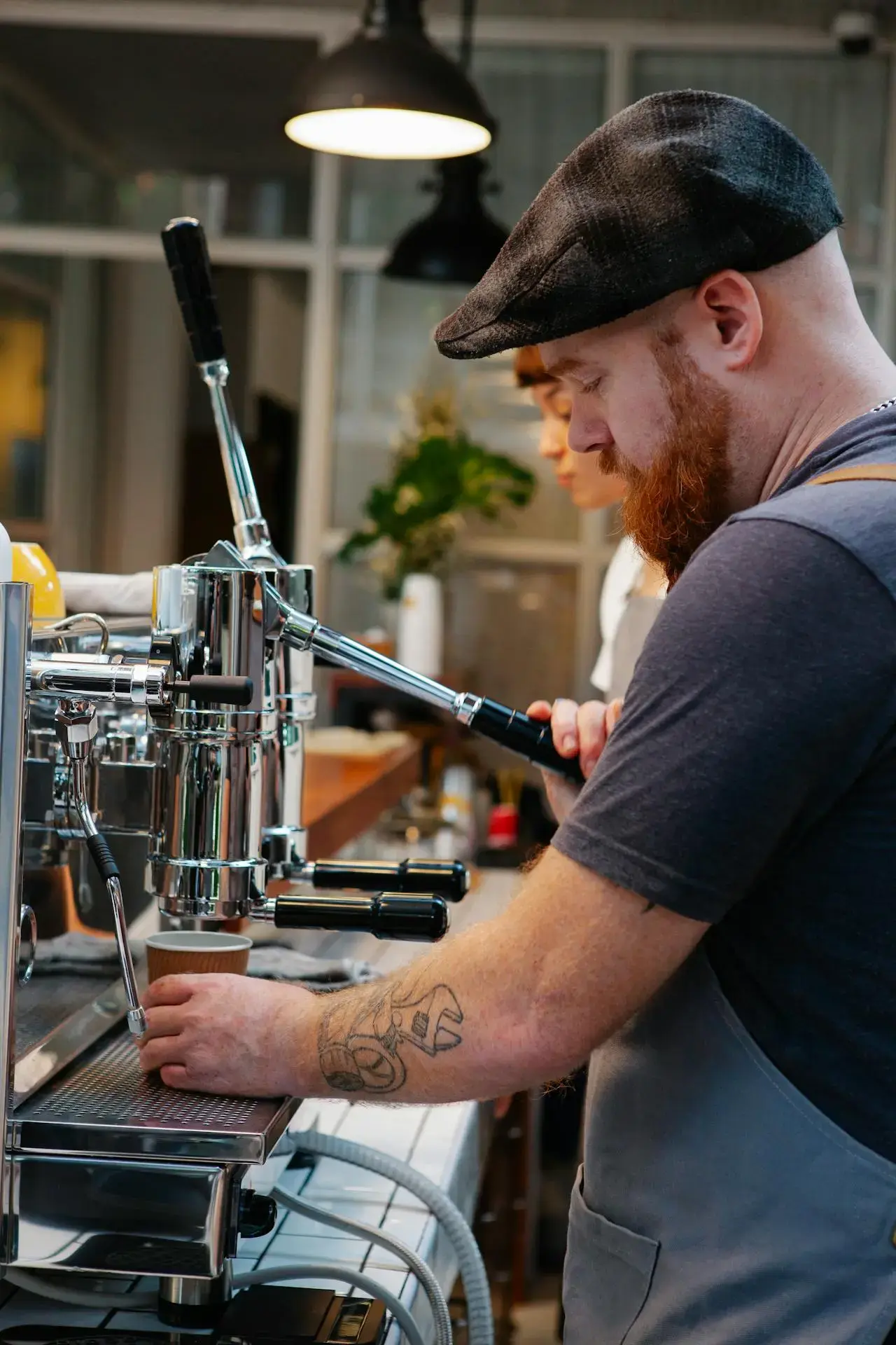 cafe wroker smiling and using POS checkout system